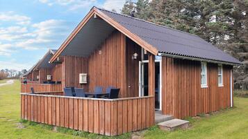 Une cabane en bois avec un balcon, une porte et une fenêtre.