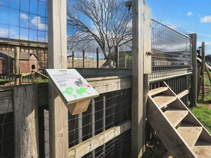A wooden fence with a metal gate, a wooden staircase, and a sign with a map and text. - 4 Star Holiday Home in Lokken (Lokken)