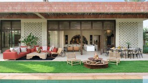 Et moderne hus med pool, udendørs møbler og en patio.