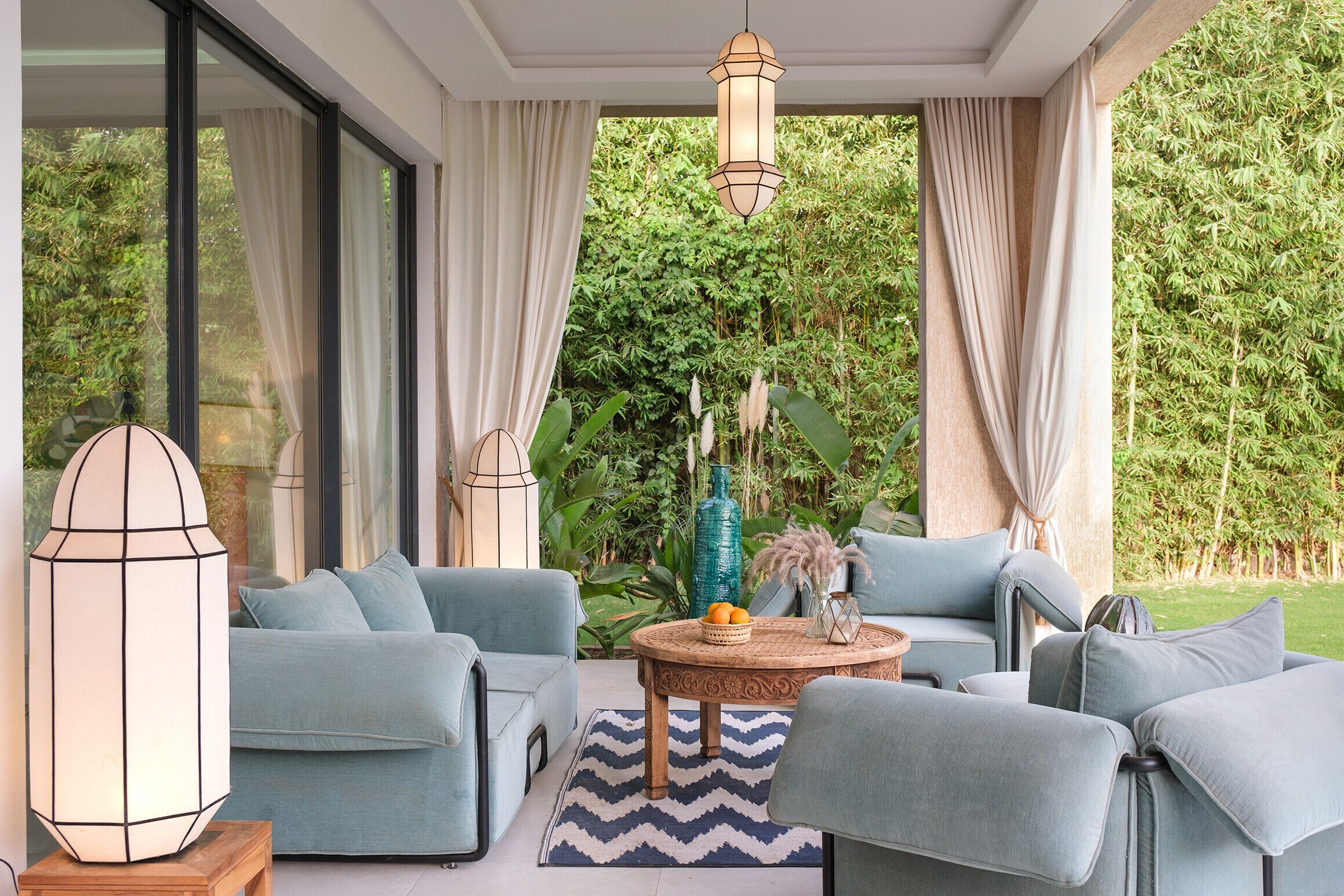 A modern living room with a sofa set, a round wooden coffee table, and a large floor lamp.