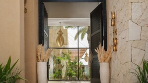 A modern entrance with a stone wall, a glass door, and potted plants. - EYLINE - luxurious villa with SPA on the Amelkis Golf course near Marrakech (Marrakech)