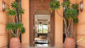 A traditional entrance with a wooden door, potted plants, and a tiled floor. - TAMARI (Marrakech)