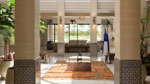 A spacious lobby with high ceilings, large windows, and a central seating area. - TAMARI (Marrakech)