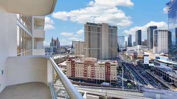 A high-rise building with multiple floors, a prominent hotel sign, and a busy urban street with a highway in the foreground.