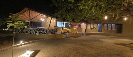 A hotel with a reception area, outdoor seating, and a covered patio.