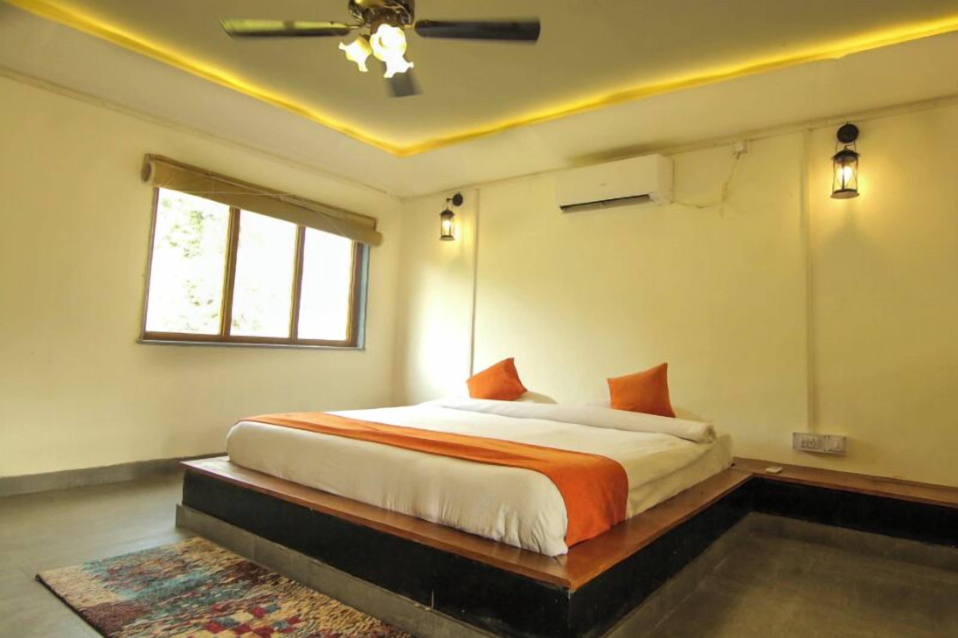 Un dormitorio con cama, ventilador de techo y dos luces fijadas a la pared.