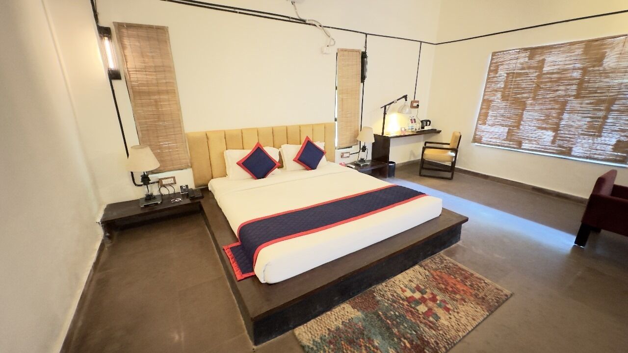 Una moderna camera d'albergo con un letto grande, una scrivania, una sedia e una finestra ampia.