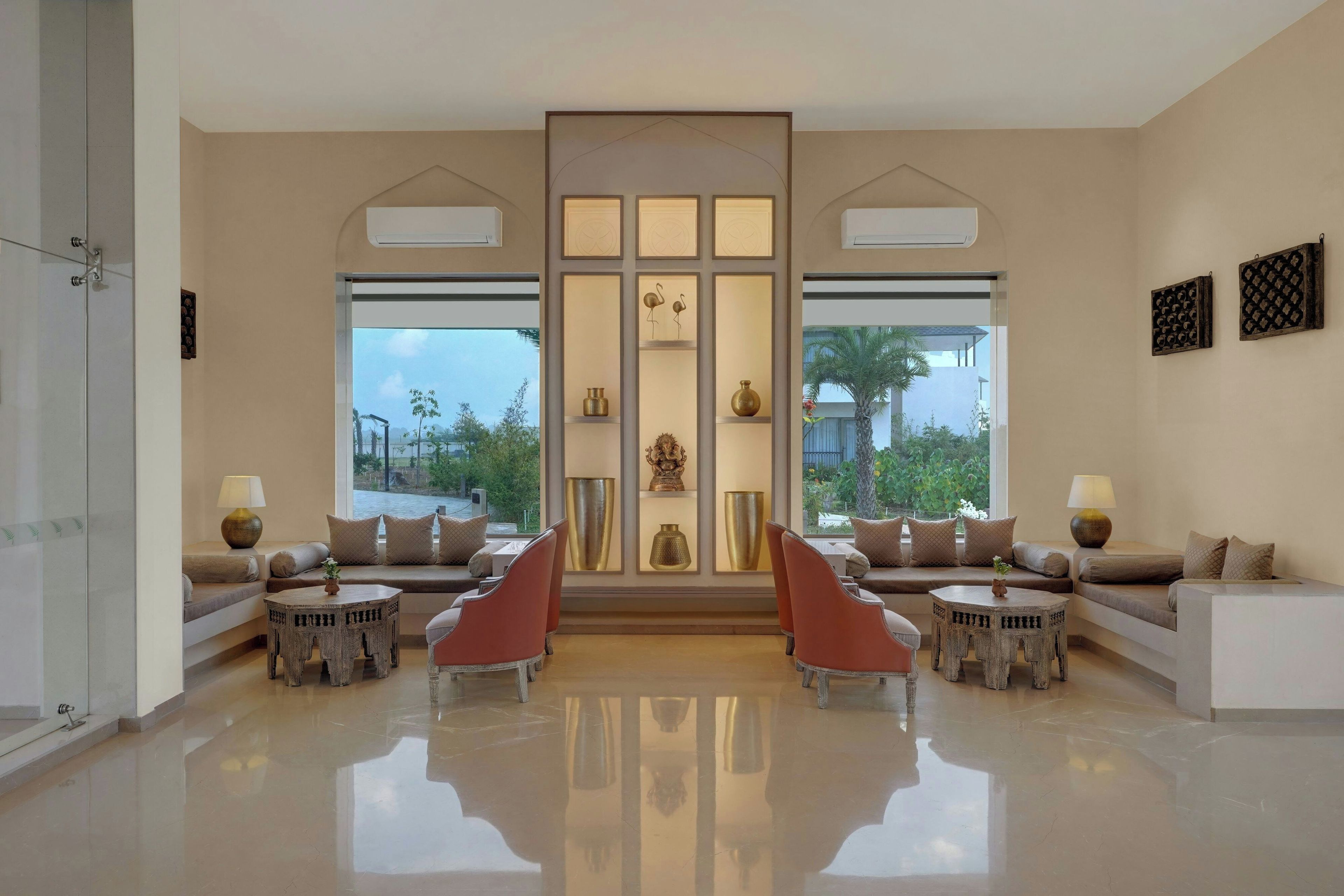A spacious lobby with a central seating area, large windows, and a decorative wall panel.