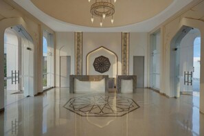 A spacious lobby with a geometric floor design, a central reception desk, and a decorative ceiling light fixture. - The Fern Sattva Resort Little Rann of Kutch, Series by Marriott (Dasada)
