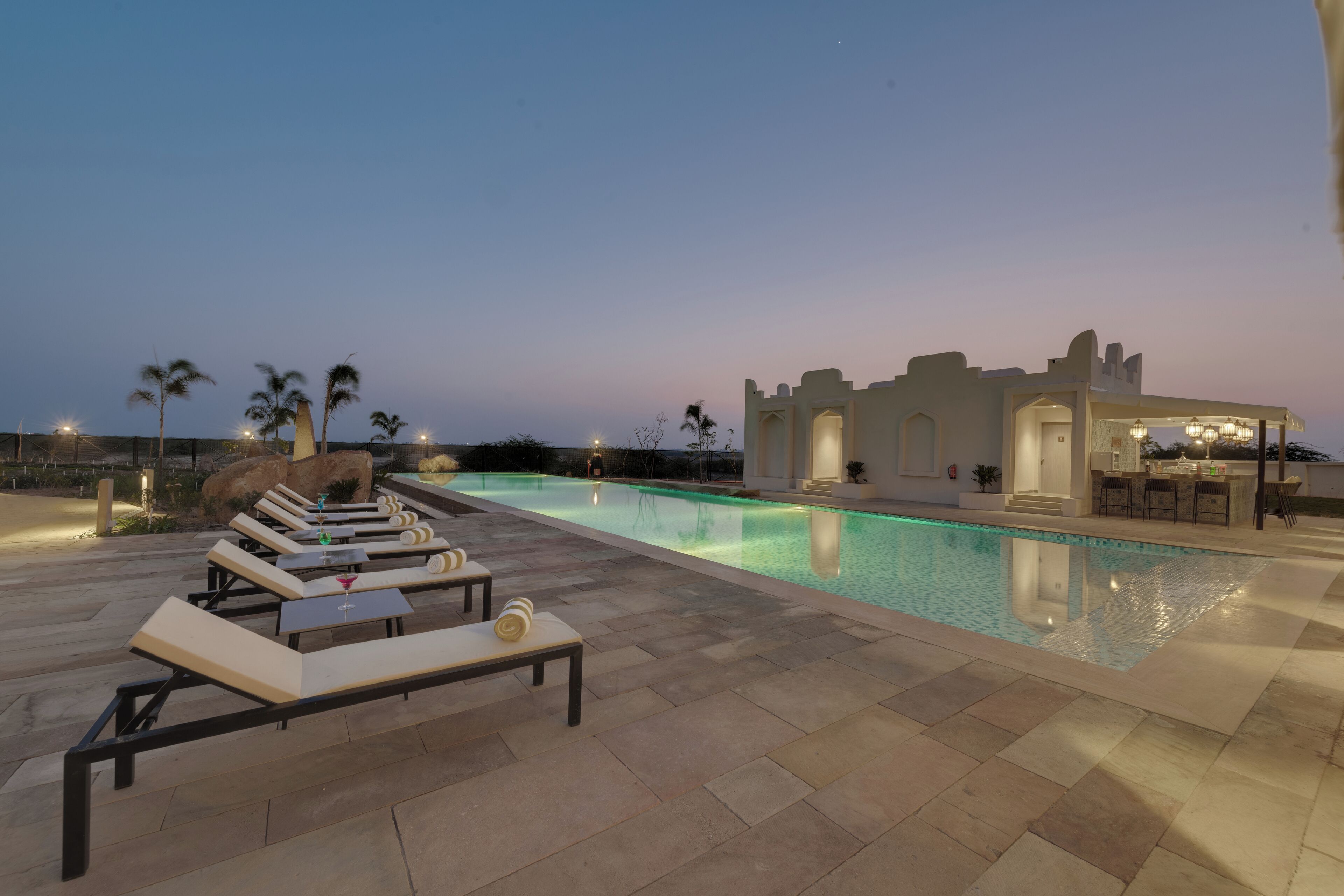 Uma área de piscina com espreguiçadeiras e um bar.