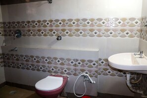 A bathroom with a toilet, sink, and shower.