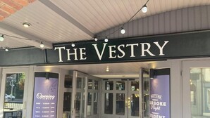 The exterior of The Vestry, a building with a sign indicating opening times and a list of events. - The Vestry (Chichester)