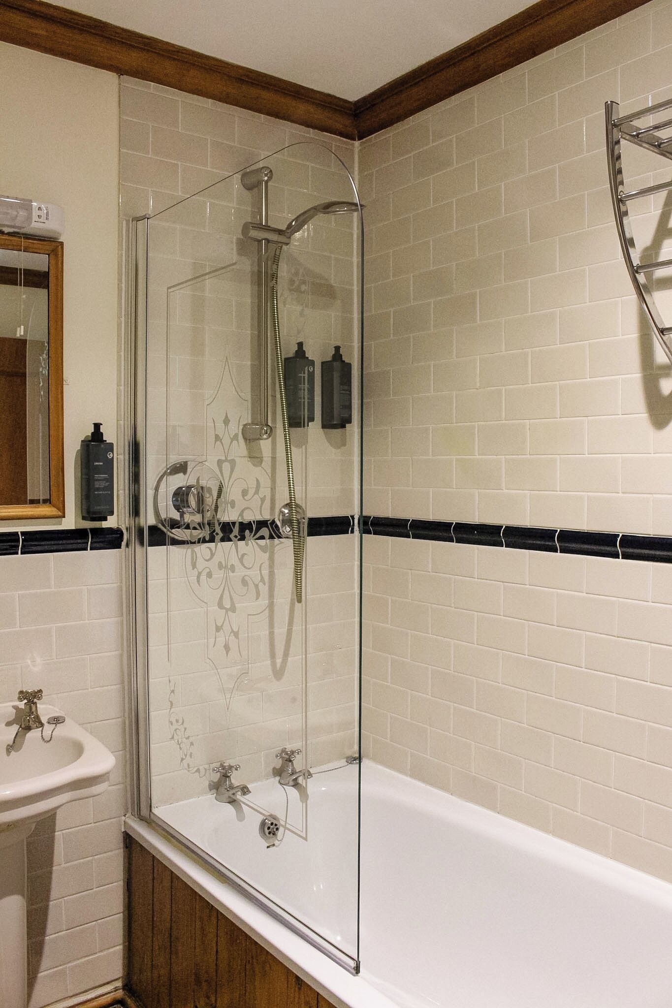 Une salle de bain avec une douche à parois de verre, un lavabo blanc et une baignoire.