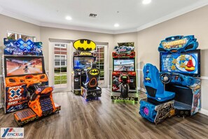 A room with arcade games including Batman, Sno Cross, and Monster Truck.
