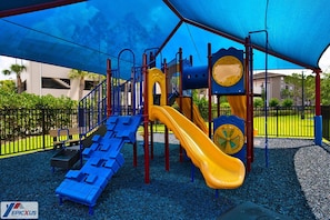 A playground with a slide, climbing structures, and a covered area.
