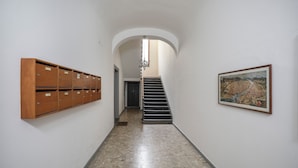 A hallway with lockers, a staircase, and a framed picture on the wall. - Synagogue Suite (Florence)