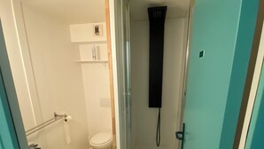 Un baño pequeño con inodoro, lavamanos y ducha.
