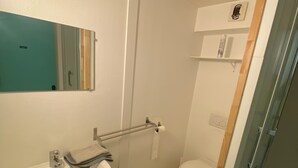Un baño pequeño con lavamanos, espejo y retrete.