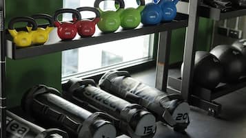 Kettlebells und Kurzhanteln auf einem Gestell im Fitnessstudio.