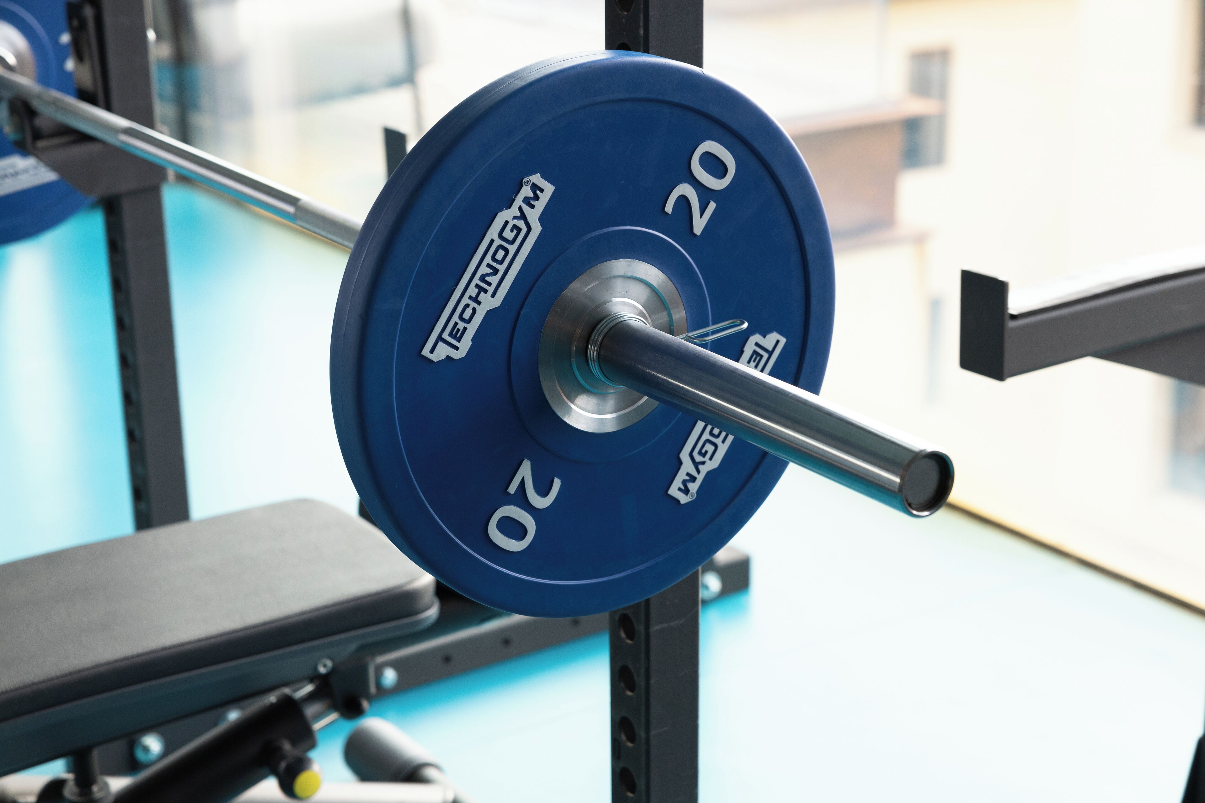 A weightlifting bench with a barbell rack.