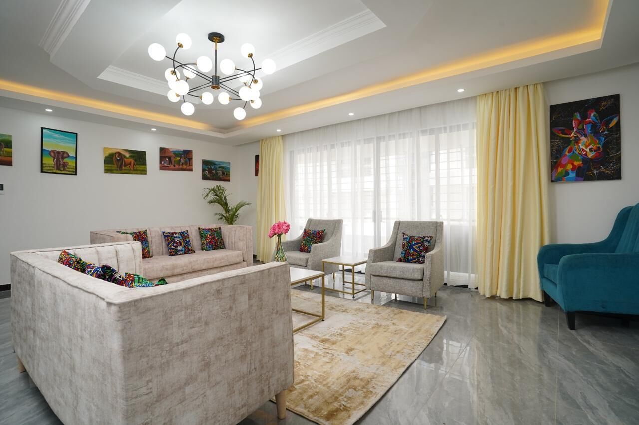 Een moderne woonkamer met een bank, fauteuils, een salontafel en een kroonluchter.