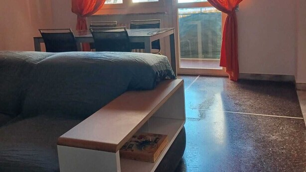 A modern bedroom with a sofa bed, a small desk, and a window with red curtains. - Family & Pet Friendly - 5 Seats - Near Ferry and Cruise Terminal - Port (Genova)