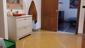 A room with a white dresser, a mirror, a brown door, and a green trash bin. - Family & Pet Friendly - 5 Seats - Near Ferry and Cruise Terminal - Port (Genova)