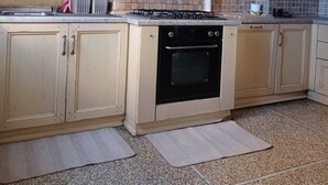 A kitchen with beige cabinets, a gas stove, an oven, and a tiled backsplash. - Family & Pet Friendly - 5 Seats - Near Ferry and Cruise Terminal - Port (Genova)
