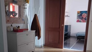 A room with a white dresser, a brown door, and a painting on the wall. - Family & Pet Friendly - 5 Seats - Near Ferry and Cruise Terminal - Port (Genova)