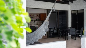 A hammock hanging over a patio area with a view of a kitchen and dining area. - Sunny Days Villa At Playa Hermosa (Playa Hermosa)