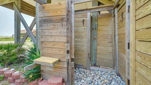Een houten constructie met een bank, een deur en een pad van stenen.