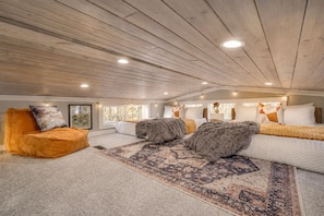 A spacious room with a high ceiling, a large window, and a cozy seating area with a patterned rug. - The Ascent at The Retreat at Deer Lick Falls II (Monteagle)