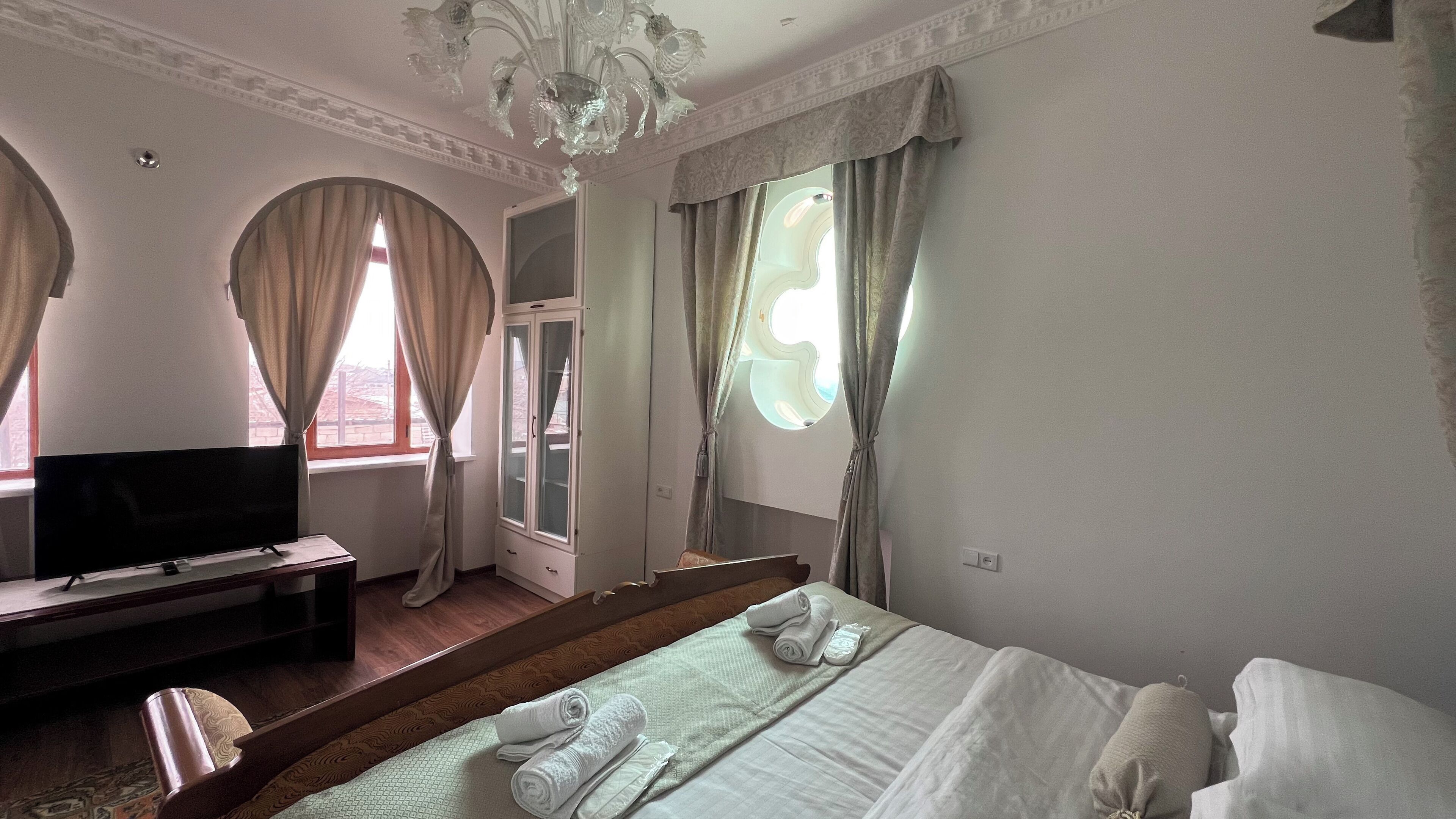 A hotel room with a bed, a television, a desk, and a wardrobe.
