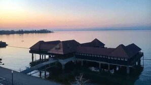 A waterfront building with multiple levels, a dock, and a calm body of water. - Apartment with shower - washing machine - 180 degree lake view (Rorschach)