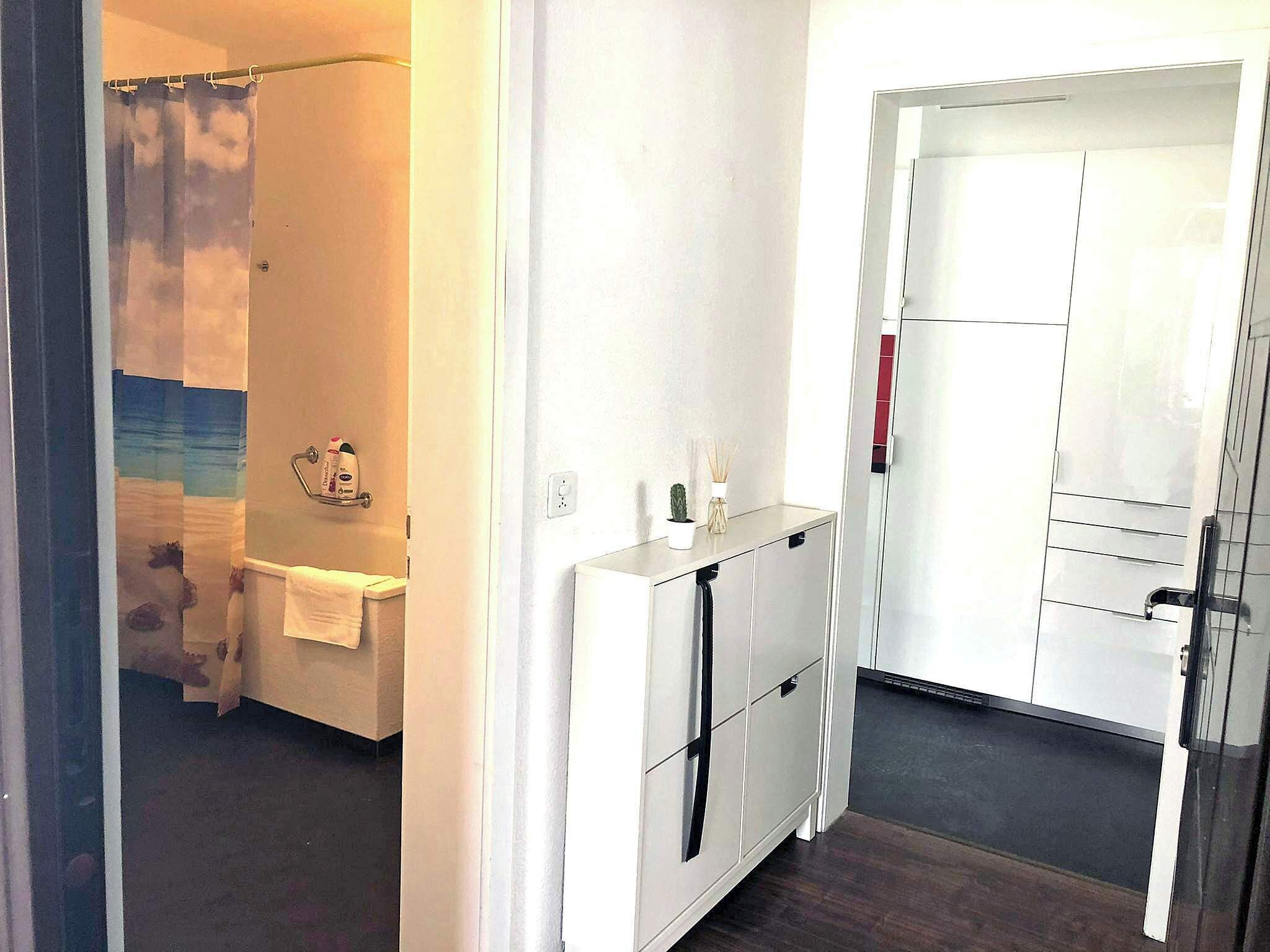 Ein Badezimmer mit Duschvorhang, Handtuchhalter und einer kleinen Ablage für Toilettenartikel.