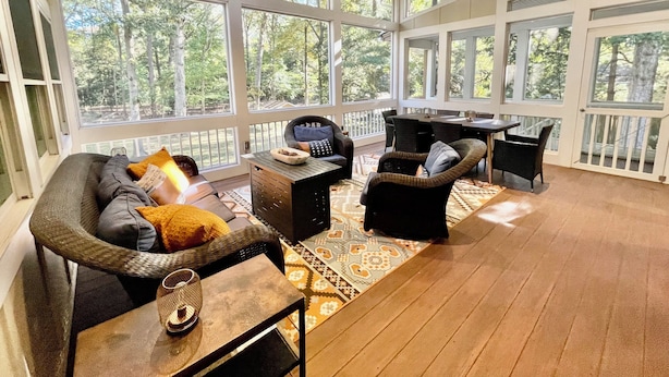 A sunroom with large windows, wicker furniture, and a ceiling fan. - Just minutes to the beach with a hot tub and fire pit! (Rehoboth Beach)