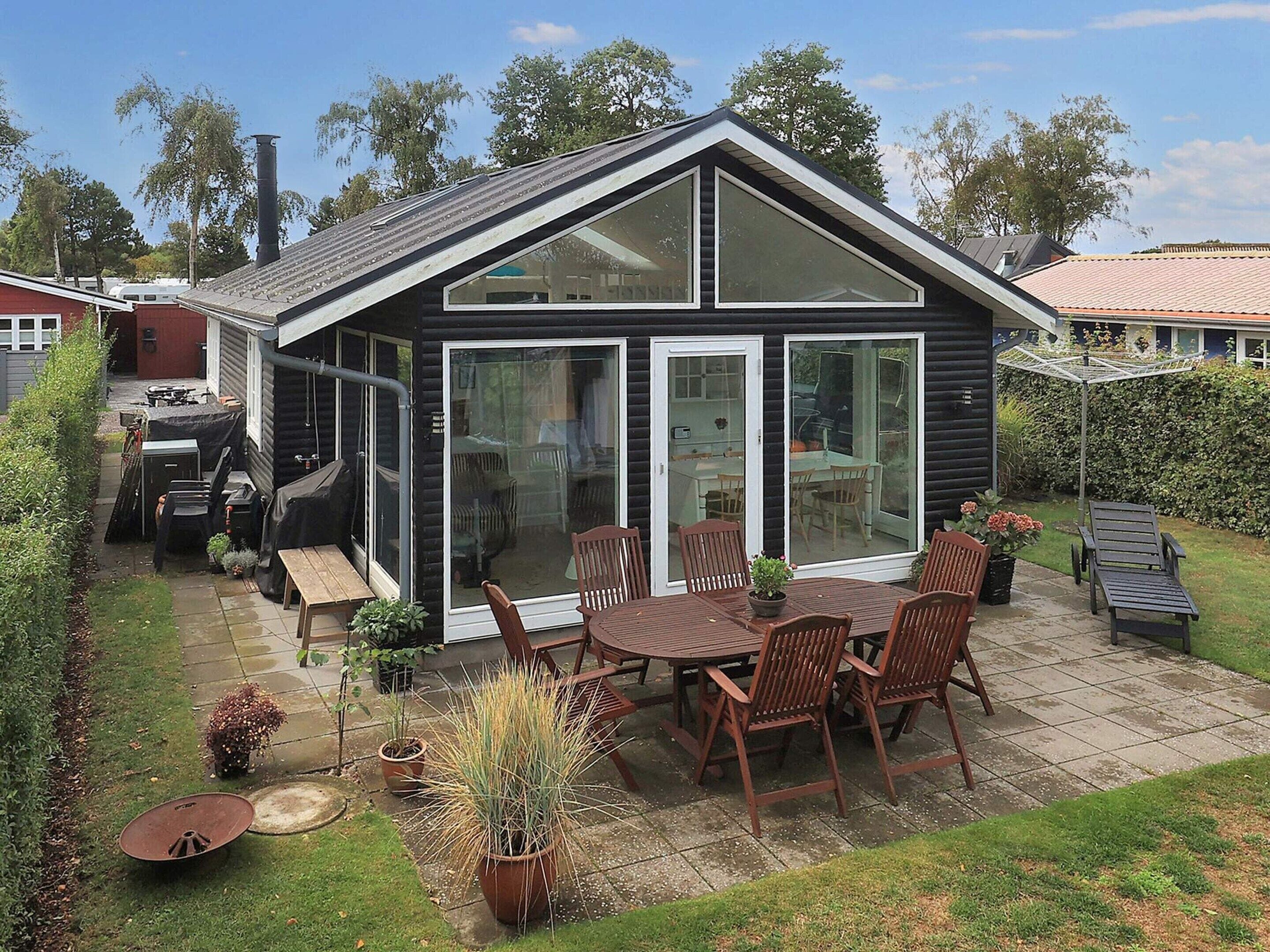 A house with a patio, a dining table with chairs, and a large sliding glass door.