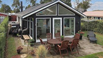 A house with a patio, a dining table with chairs, and a large sliding glass door.