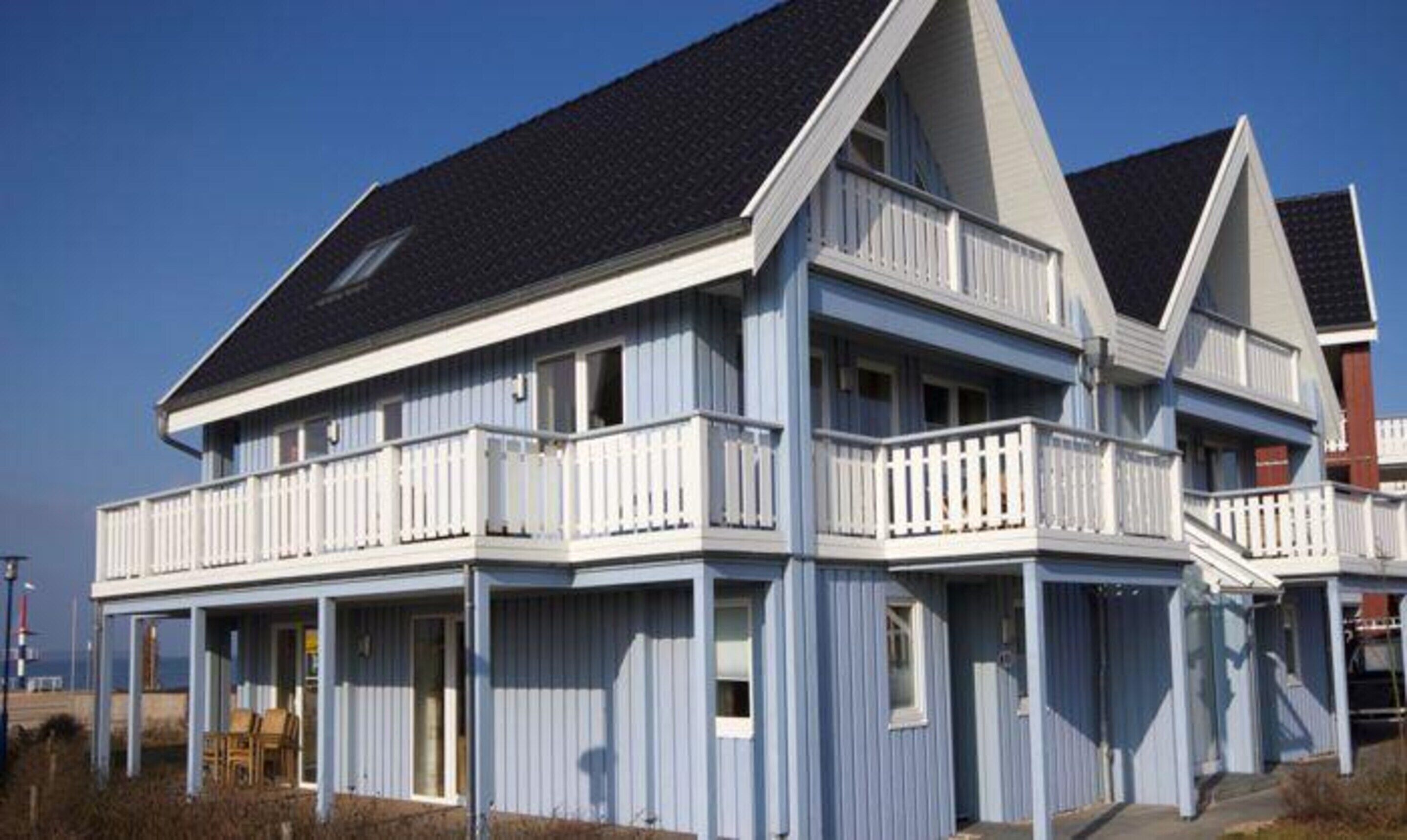 Un bâtiment à deux étages, doté d’un balcon au rez-de-chaussée et d’un toit à forte pente.