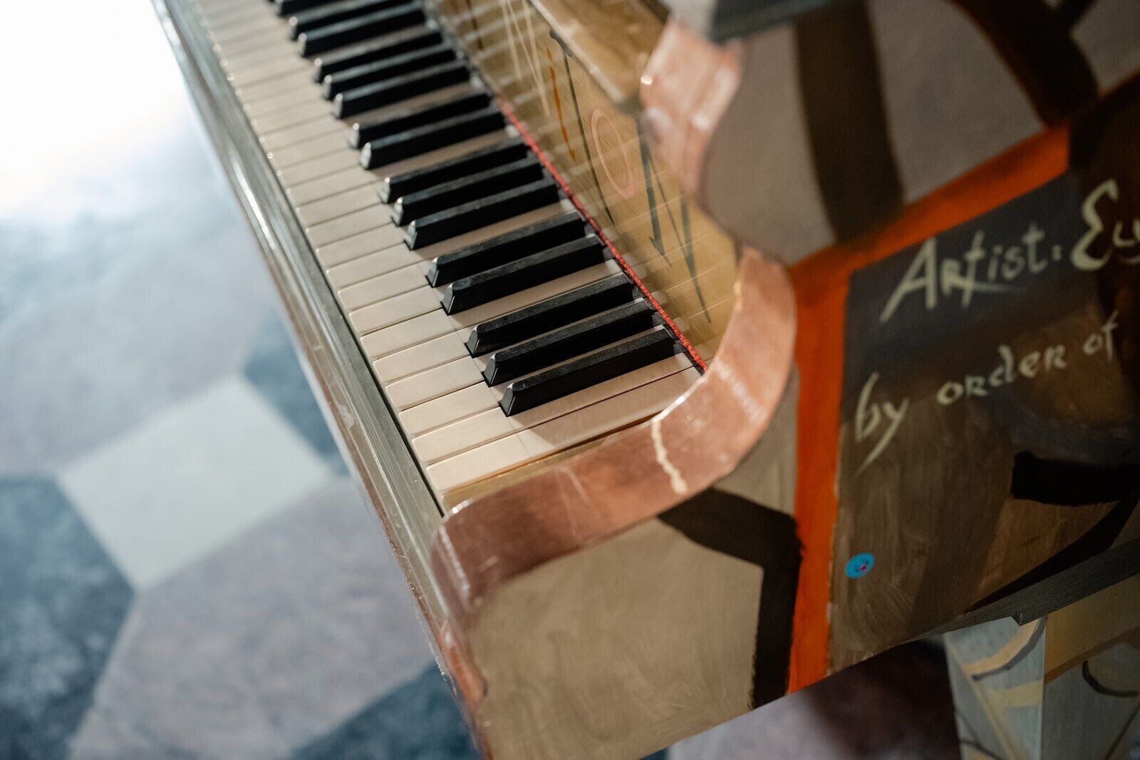 Ein Klavier mit Holzfurnier und einem Schild mit der Aufschrift 'Artist. E.'