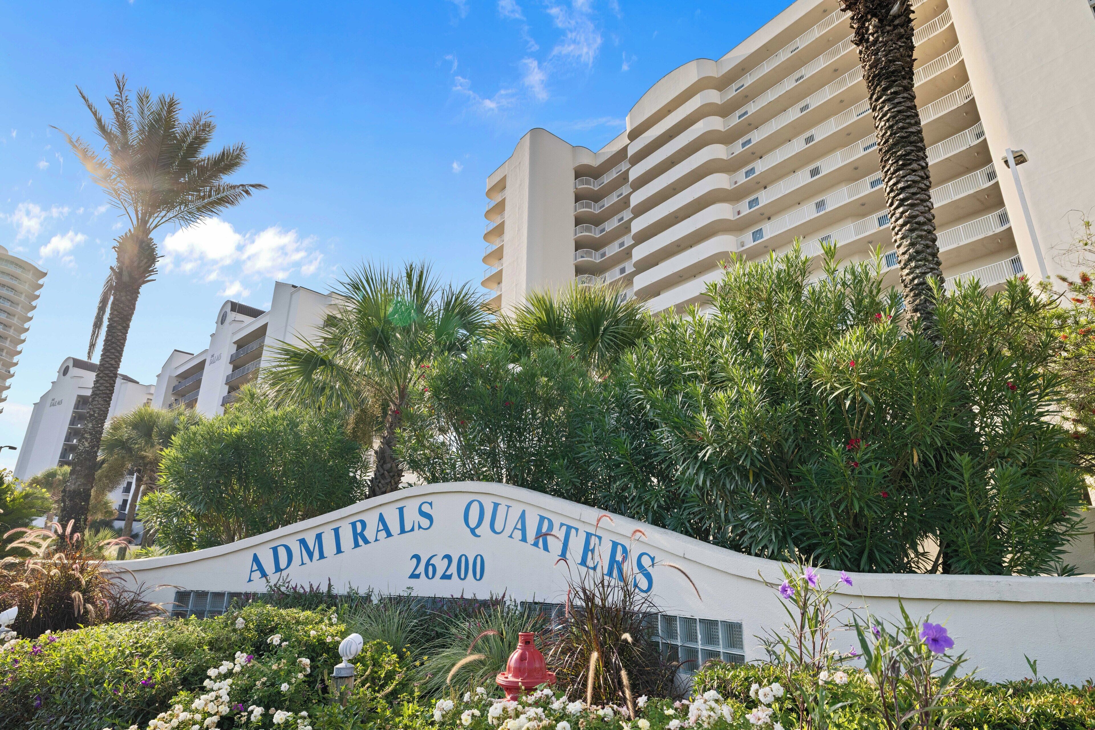 A sign for 'Admirals Quarters' with a building in the background.