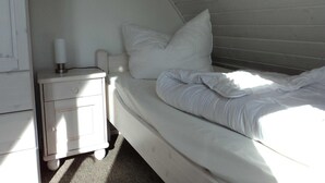 Ein Schlafzimmer mit einem Bett, einem Nachttisch und einem Wandbild.