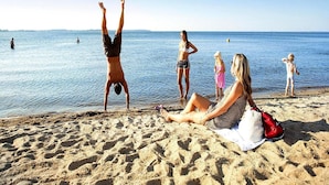 A beach scene with people relaxing and engaging in activities. - Liebevoll Eingerichtetes Appartement (Rechlin)