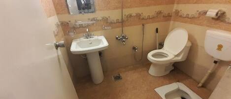 A small bathroom with a sink, toilet, and bidet.
