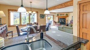 Una cocina espaciosa con una isla grande, electrodomésticos modernos y un comedor con chimenea.