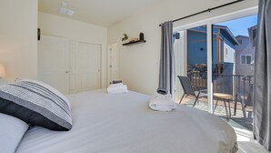 A hotel room with a bed, a small balcony with chairs, a sliding glass door, and a ceiling fan. - 2 Mi to Dtwn Flagstaff: Home w/ Balcony! (Flagstaff)