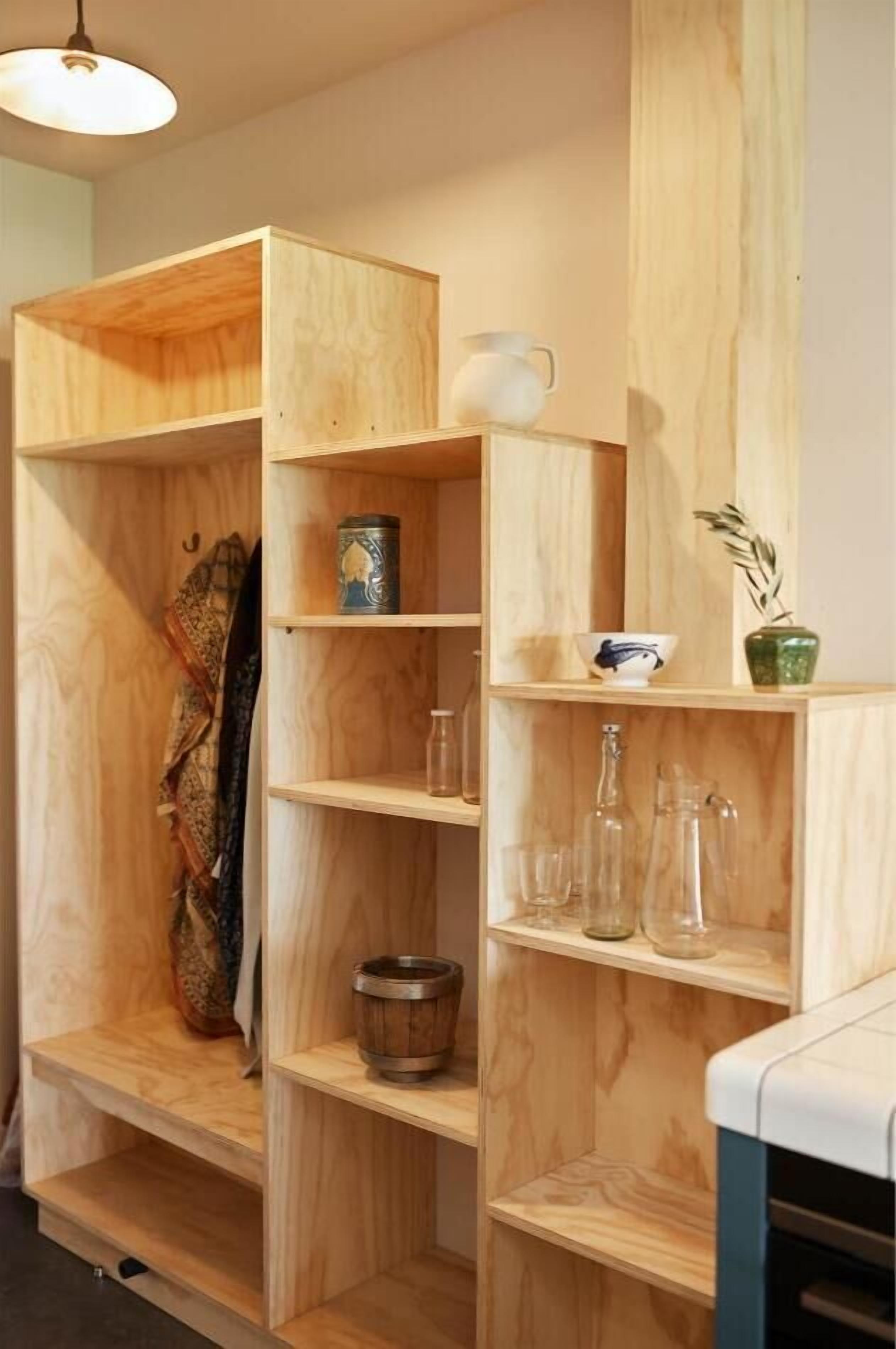 Ein Holzregal mit verschiedenen Gegenständen, darunter eine Tasse, eine Schüssel, eine Vase und Glaswaren.