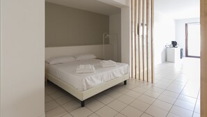 Un dormitorio moderno con una cama grande, un separador de madera y vistas de la habitación contigua.