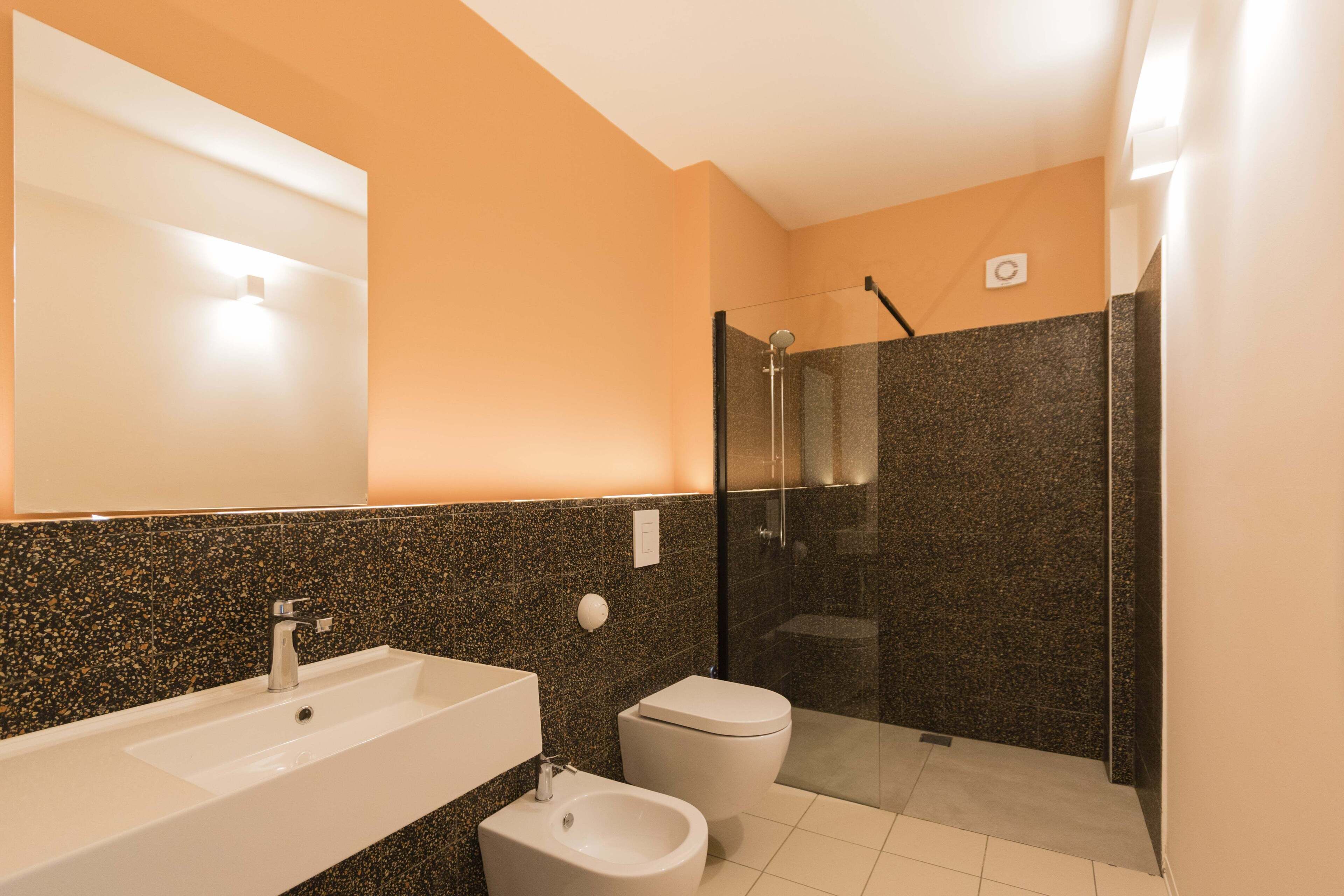 Ein Badezimmer mit Waschbecken, Toilette, Bidet und einer Duschkabine.