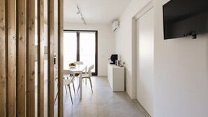 Eine moderne Küche mit Essbereich, einem an der Wand befestigten Fernseher und einer Holzwand.